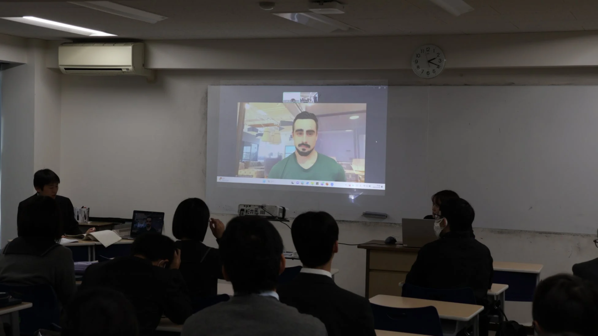 プロジェクターに映し出されたオンラインプレゼンテーションを見る生徒たち