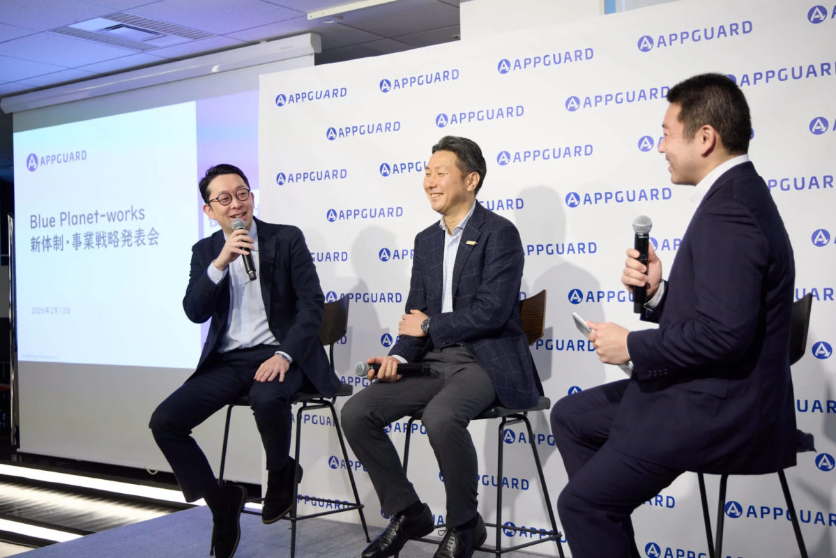 記者会見で談笑する3人の男性