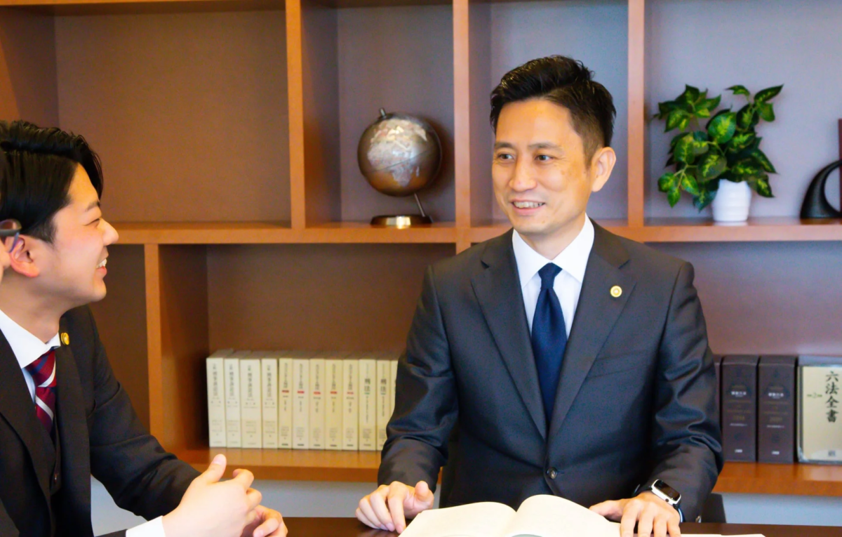 オフィスでスーツを着た2人の男性が向かい合って話している