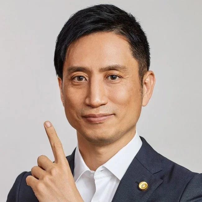 スーツを着たアジア人男性が笑顔で指を上に差しているポートレート